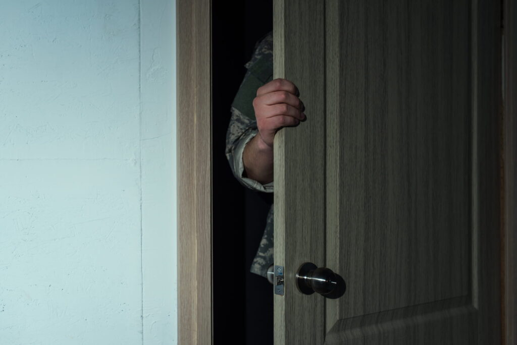 Someone illegally entering a home throw a doorway
